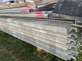 a pile of steel bars stacked on top of each other in the grass