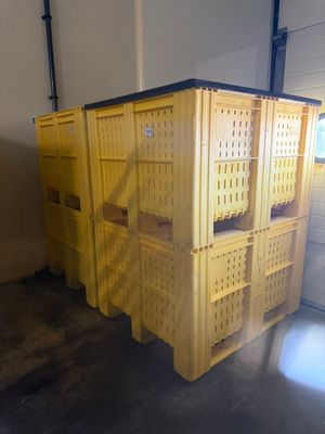 de nombreuses caisses jaunes empilées dans un garage