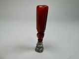 a red glass vase with a silver base on a white table