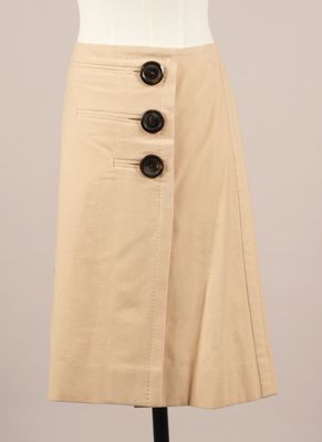 une jupe beige avec des boutons sur le devant et sur le côté