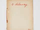 un vieux livre portant des inscriptions rouges, posé sur une surface blanche