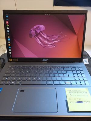 un ordinateur portable posé sur un bureau, sur lequel est collé un post-it