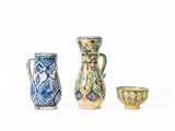 trois petits vases posés les uns à côté des autres sur une surface blanche