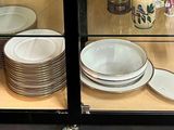 many plates and bowls on display in a glass case