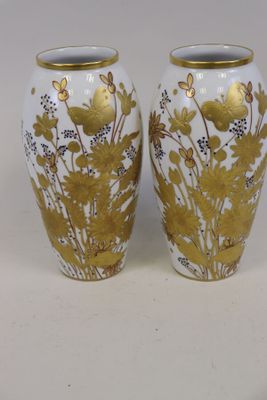 deux vases ornés de motifs dorés et blancs