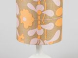 un gros plan d'une lampe posée sur une table, avec un pied blanc