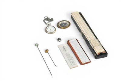 a clock, a pocket watch, a book, and a pen on a white surface