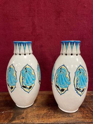 two vases sitting on a wooden table with a red background