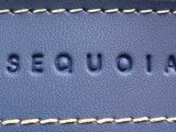 a close up of a blue leather bag with a name on it