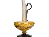 a glass vase with a black handle on a stand