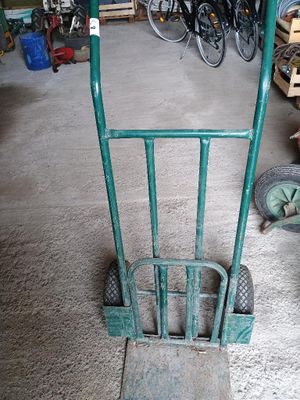 un diable vert muni d'une poignée métallique, dans un garage