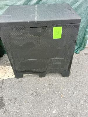une boîte noire sur laquelle est collé un autocollant vert