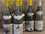 several bottles of wine are lined up on a wooden shelf