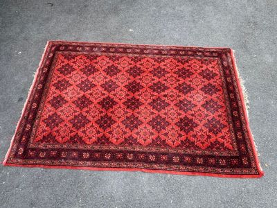 a red and black rug on the ground