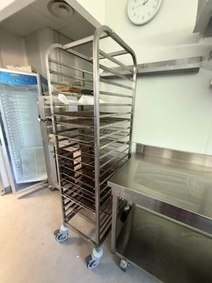 a metal rack with trays of food in a kitchen