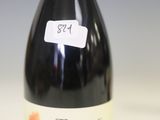 une bouteille de vin posée sur une table à côté d'une bouteille de vin