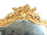 a large mirror with a gold frame in a room