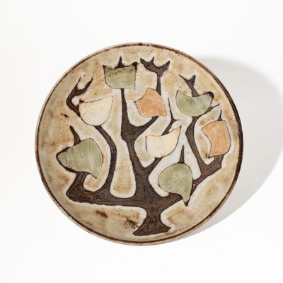 une assiette blanche ornée d'un motif d'arbre