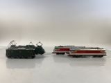 two toy trains sitting side by side on a white surface