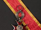 a close up of a medal on a red and yellow ribbon