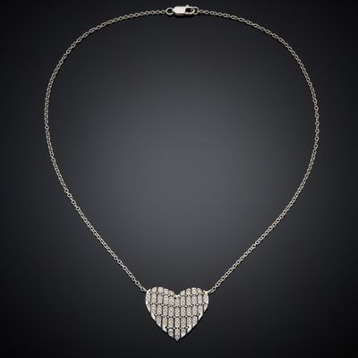 a diamond heart pendant on a chain on a black background