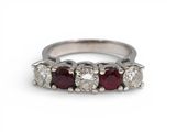 une bague en or blanc sertie de cinq diamants de taille ronde et d'un rubis rouge