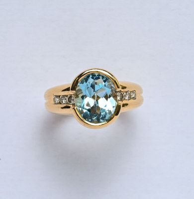 Bague en or jaune 18K (750/oo) centrée d'une topaze bleue ov…