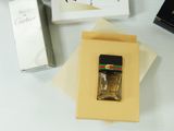 a bottle of perfume sitting on top of a table next to a box of cigarettes