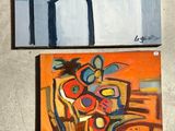 three paintings on a wall in a room with a chair and a table