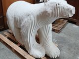 a white sculpture of a polar bear sitting on a pallet