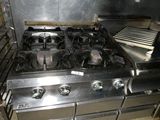 a large stainless steel stove top in a commercial kitchen
