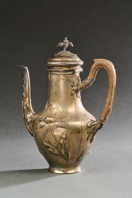 une théière ancienne en argent surmontée d'un oiseau