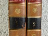 two old books sitting on top of a table next to each other