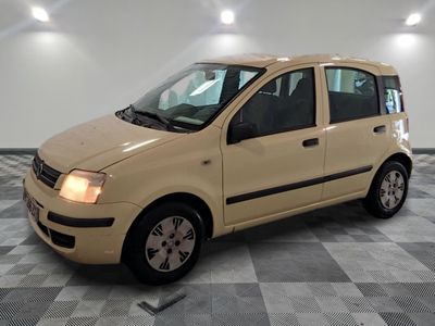 une photo d'une petite voiture beige garée dans un garage