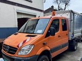 un camion orange garé devant un immeuble