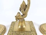 three brass figurines of a bird on a square base