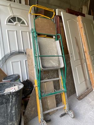 une échelle appuyée contre un mur, à côté d'une rangée de portes