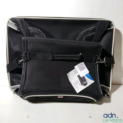 un sac noir muni d'une étiquette, posé sur une table