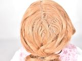 a close up of a doll with a braid in her hair