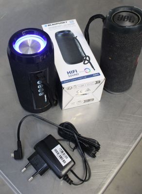 a box with a speaker and a charger on a table