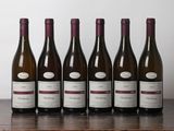 six bottles of wine are lined up on a wooden table