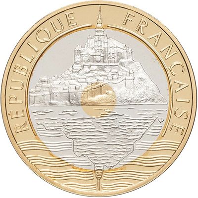 a close up of a coin with a boat in the water