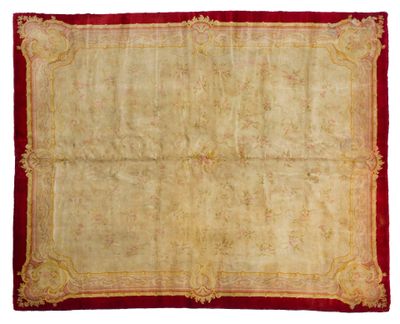 un tapis ancien avec une bordure rouge et une bordure dorée