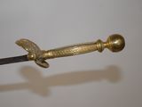 a gold colored sword with a black handle on a white background