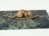 a statue of a mouse sitting on a piece of marble