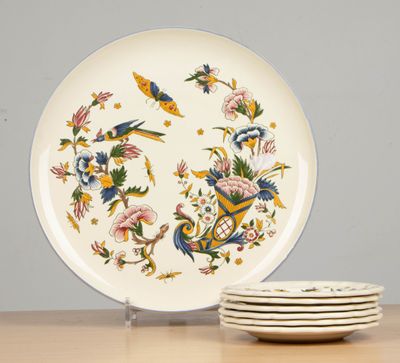 plusieurs assiettes et bols posés sur une table en bois, sur fond gris