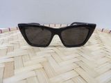 a close up of a pair of black sunglasses on a woven basket
