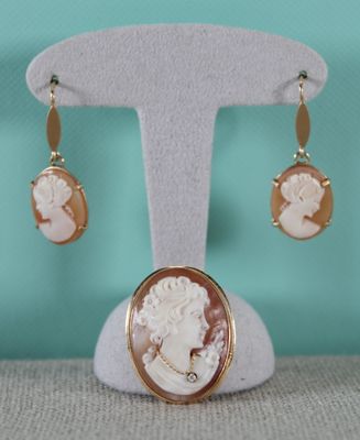 un gros plan sur une paire de boucles d'oreilles ornées d'une image représentant une femme