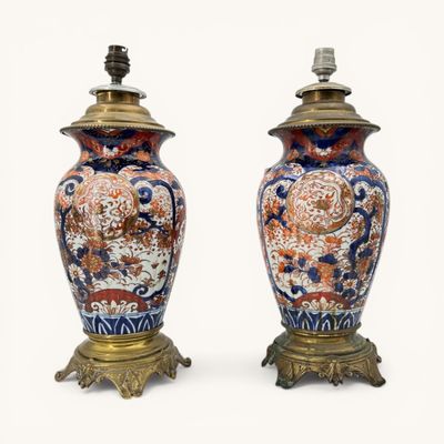 pair of antique chinese vases on stands with lamps on top of them