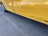 a yellow car that is parked in a parking lot